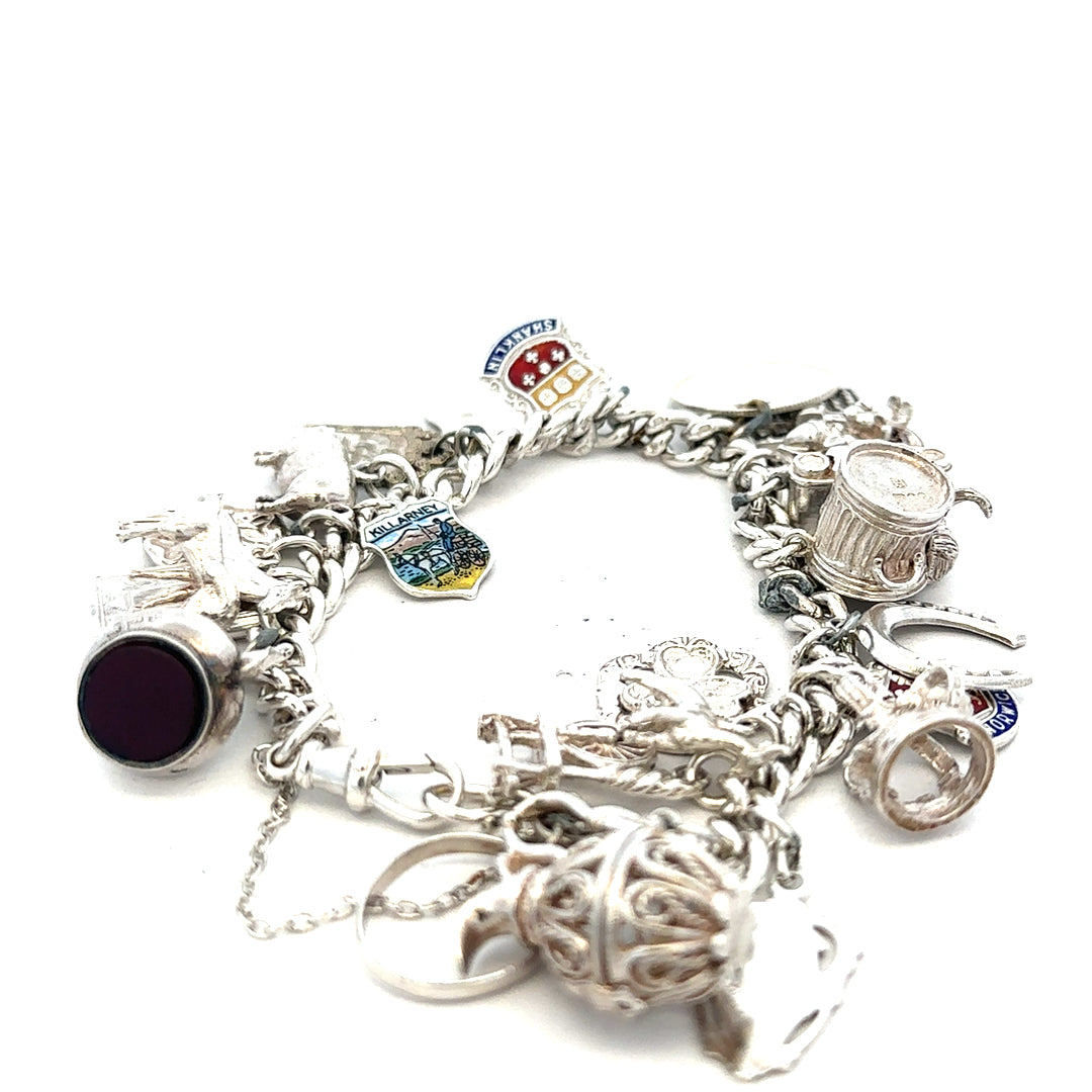 Silver charm bracelet weighing 61g with various decorative charms, unbranded jewelry accessory on a neutral background.