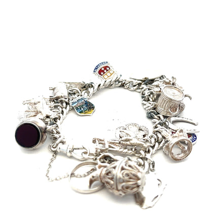 Silver charm bracelet weighing 61g with various decorative charms, unbranded jewelry accessory on a neutral background.