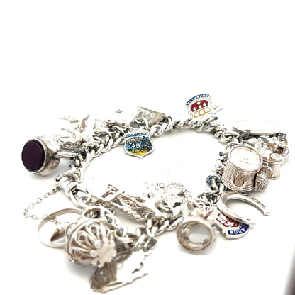 Silver charm bracelet weighing 61g, unbranded, featuring various decorative charms on a sleek silver band.