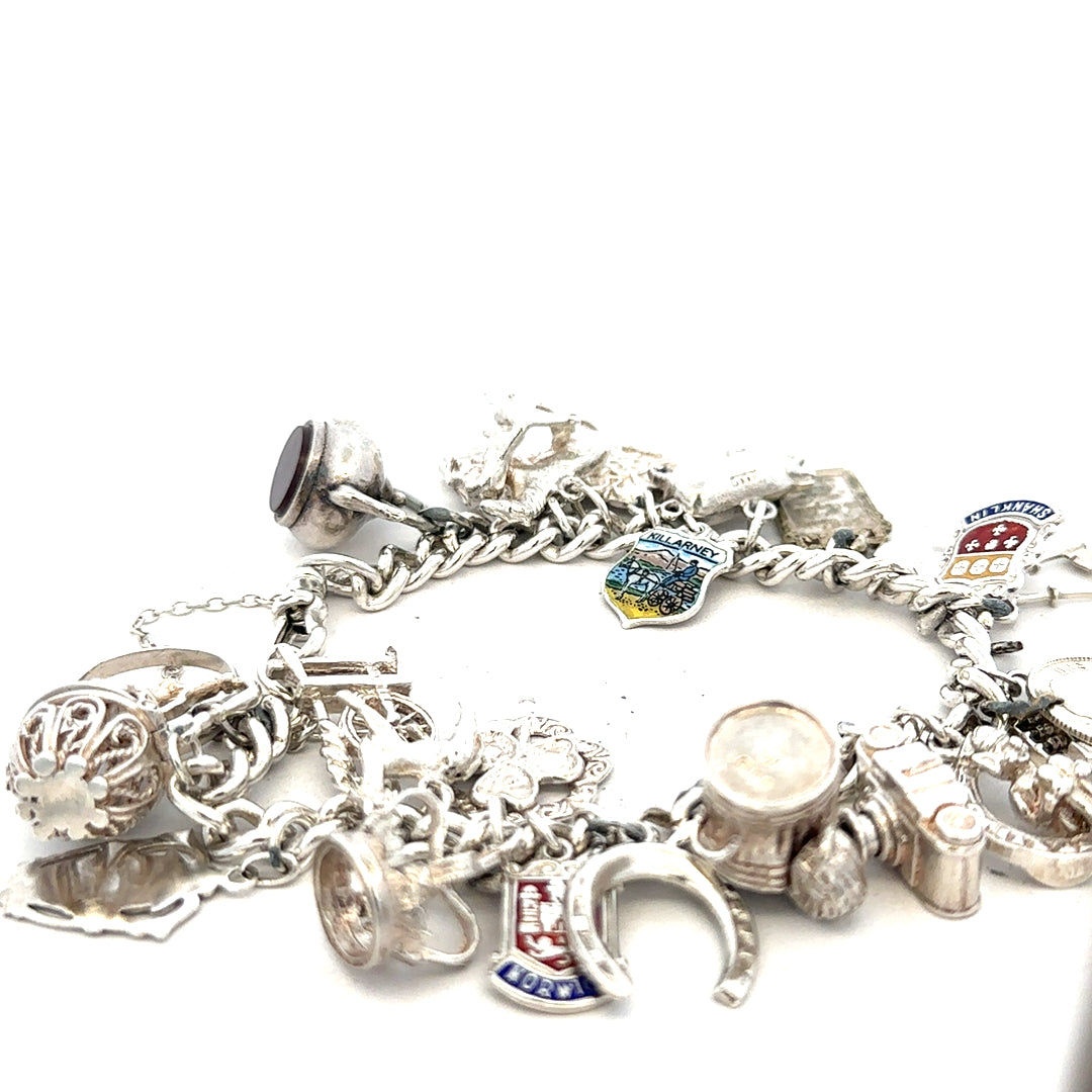 Silver charm bracelet weighing 61g with decorative charms, unbranded jewelry accessory, shown in a detailed close-up image.