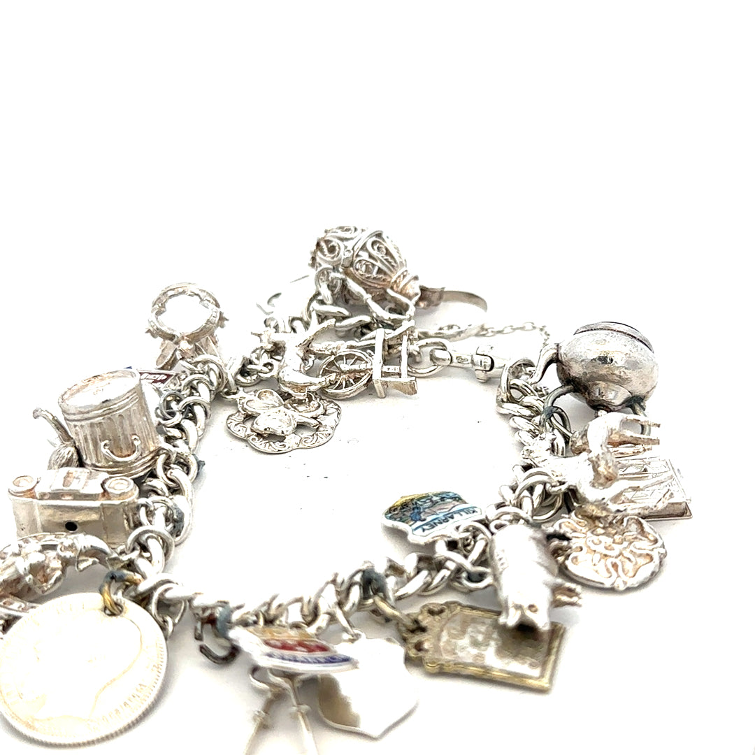Silver charm bracelet weighing 61g with various decorative charms, unbranded jewelry accessory on a neutral background.