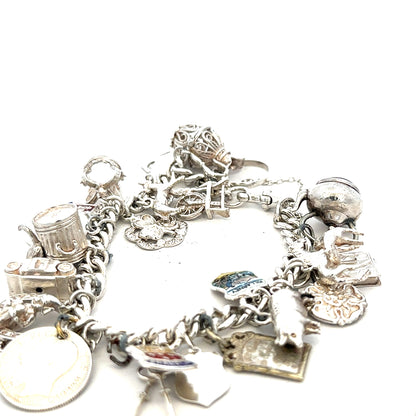 Silver charm bracelet weighing 61g with various decorative charms, unbranded jewelry accessory on a neutral background.