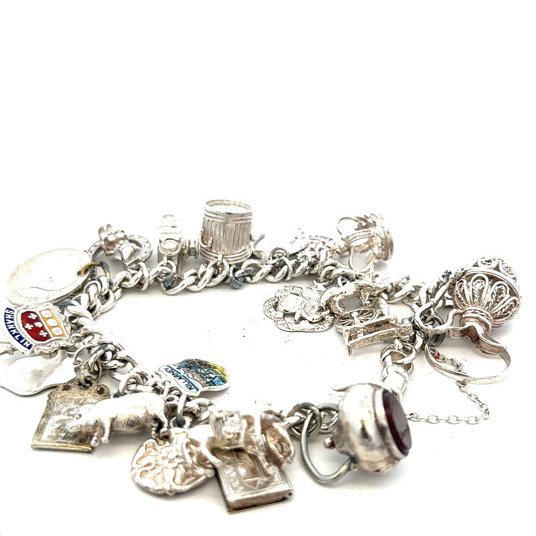 Silver charm bracelet weighing 61g with various charms, unbranded jewelry accessory, displayed on a plain background
