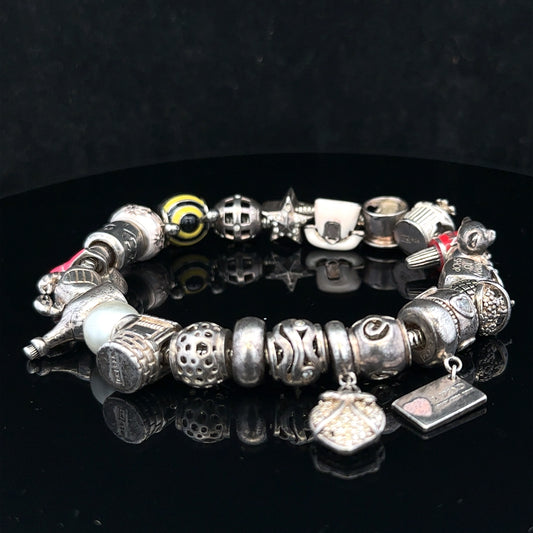 Silver charm bracelet with multiple decorative charms, unbranded, featuring a 64.8 cm length and silver finish.