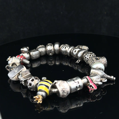 Silver charm bracelet with multiple charms, 64.8 cm length, unbranded, featuring a sleek and stylish design.