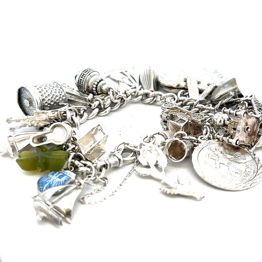 Silver charm bracelet weighing 83.4g with decorative charms, featuring a sleek and stylish design, unbranded jewelry accessory.
