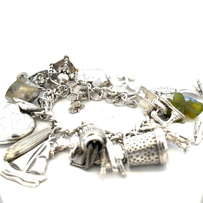 Silver charm bracelet with intricate details, weighing 83.4g, featuring multiple charms on a stylish bracelet design.