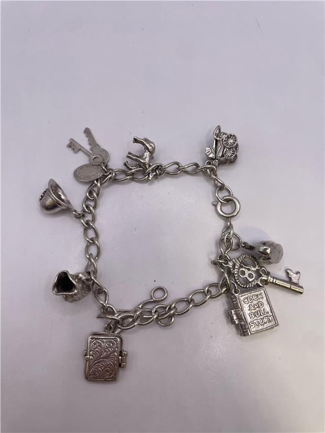 Silver charm bracelet with intricate details, weighing 33.9g, featuring various charms on a stylish bracelet chain.