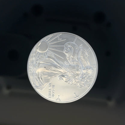 Silver one dollar coin weighing 31.2g with detailed engravings, unbranded, shown in a close-up image.