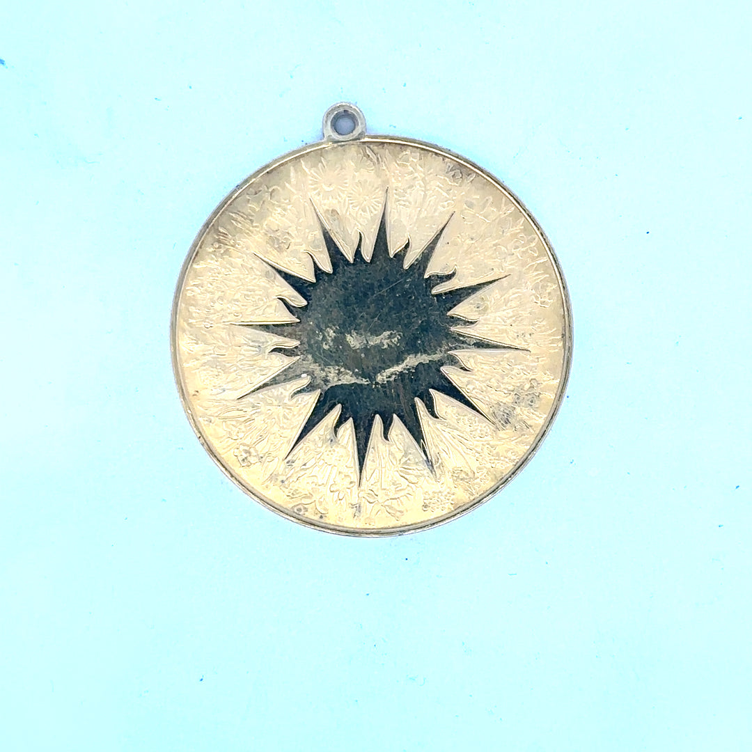 Silver pendant weighing 25.4g with intricate design, jewelry accessory, unbranded, displayed on a neutral background