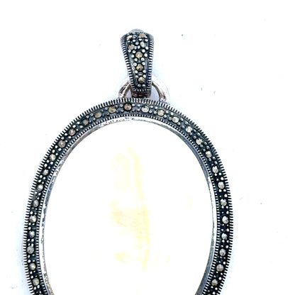 Silver pendant weighing 32.5g, unbranded, shown with detailed close-up of its polished surface and pendant shape.