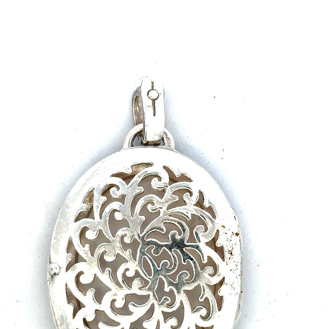 Silver pendant weighing 32.5g, unbranded, with intricate design, shown in close-up image highlighting its details.