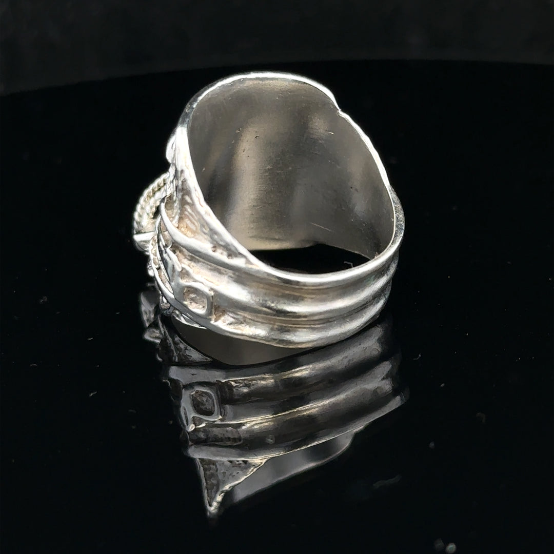 Silver saddle ring in size V, unbranded, featuring a smooth, polished design with a rounded saddle shape and shiny finish.