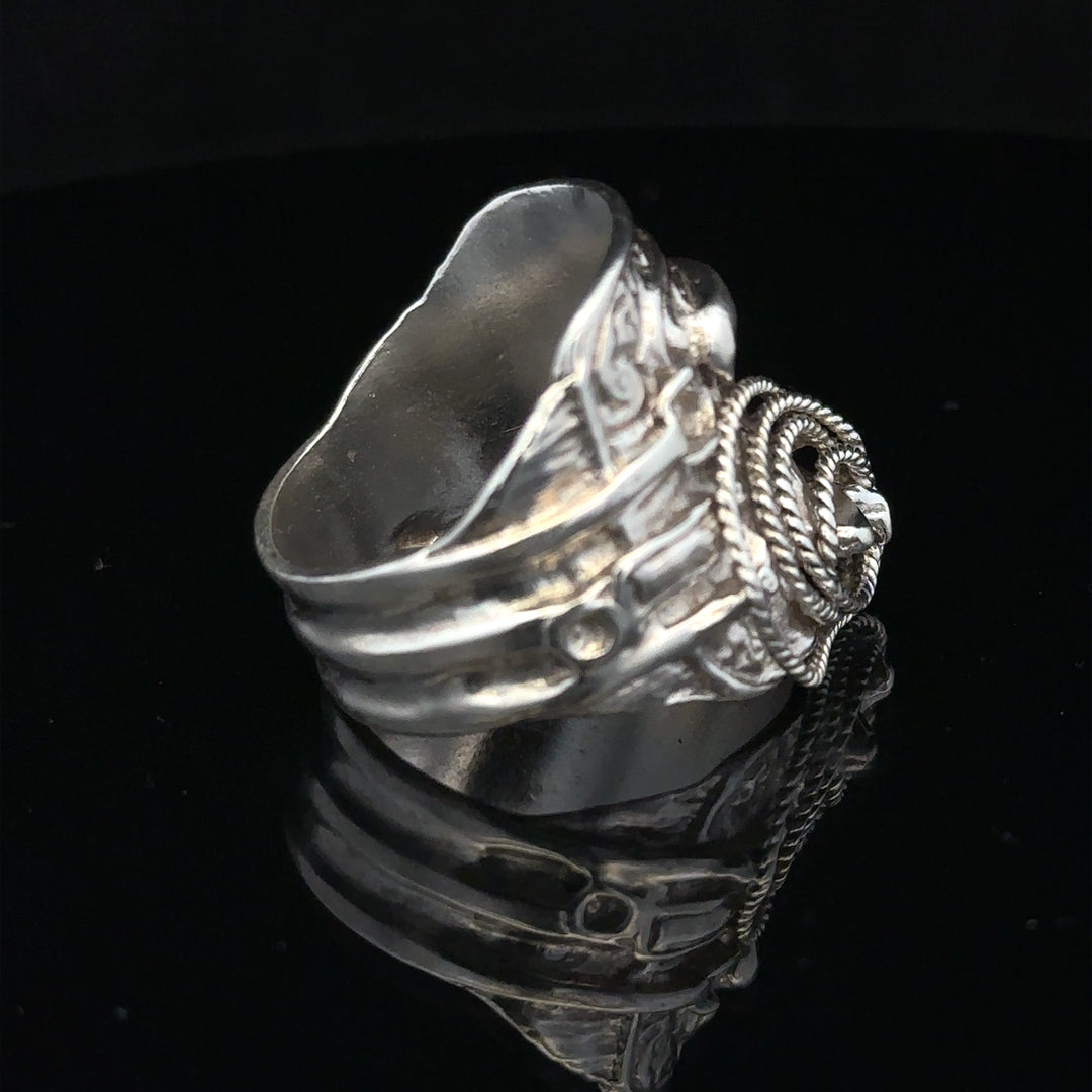 Silver saddle ring, size V, unbranded, featuring a smooth, polished band with a distinctive saddle-shaped design.