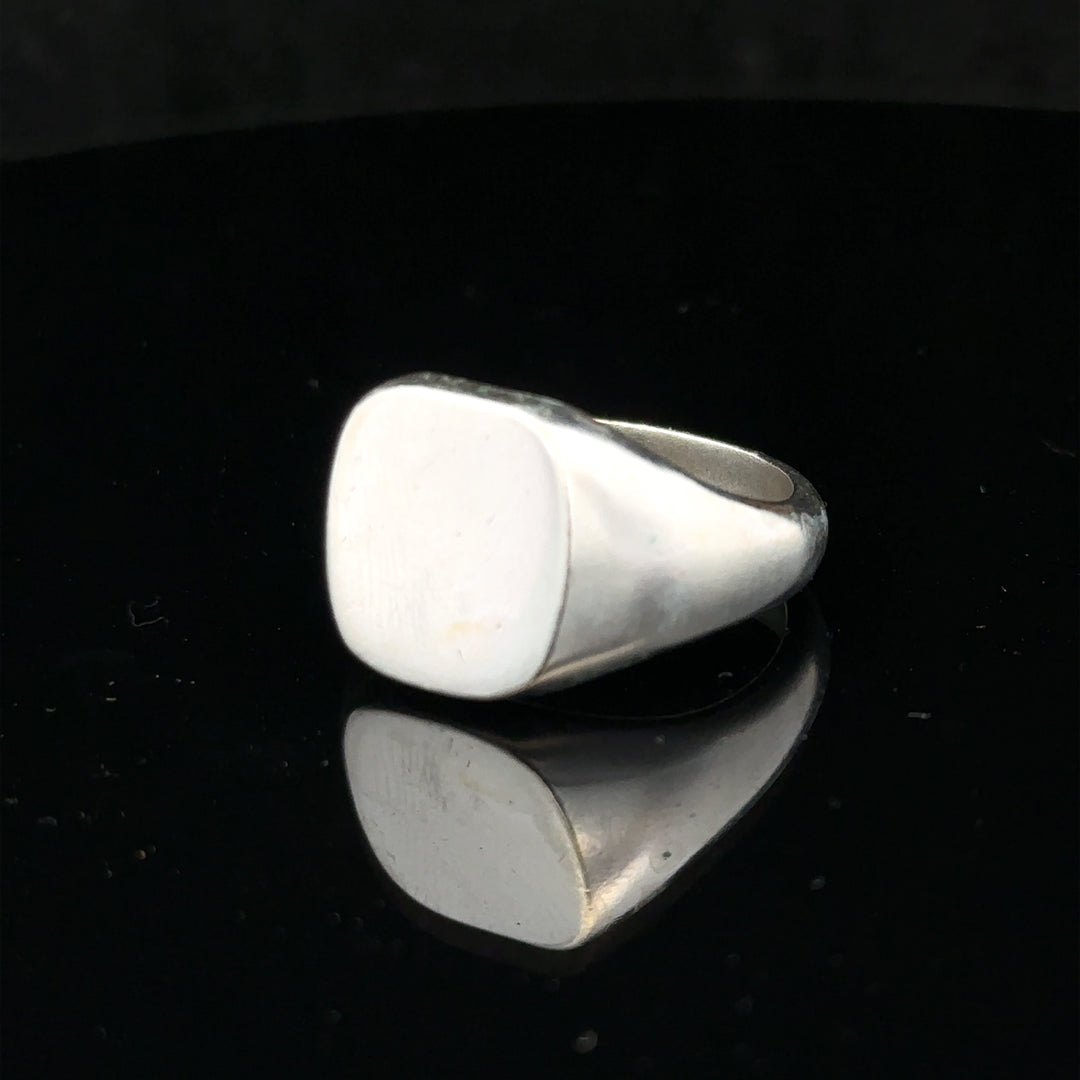 Silver signet ring in size V, unbranded, featuring a smooth, polished surface and classic design, shown in a close-up image.