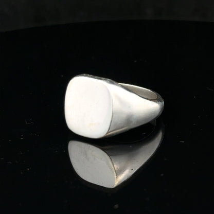 Silver signet ring in size V, unbranded, featuring a smooth, polished surface and classic design, shown in a close-up image.
