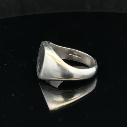Silver signet ring in size V with a smooth, polished finish, unbranded jewelry piece featuring a classic design.
