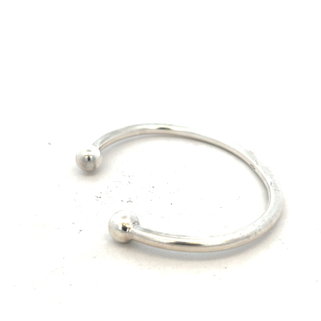 Silver torque bracelet with a 20g weight, featuring a sleek unbranded design, displayed on a neutral background.