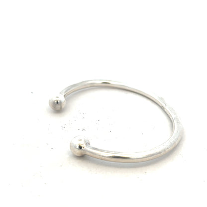 Silver torque bracelet with a 20g weight, featuring a sleek unbranded design, displayed on a neutral background.