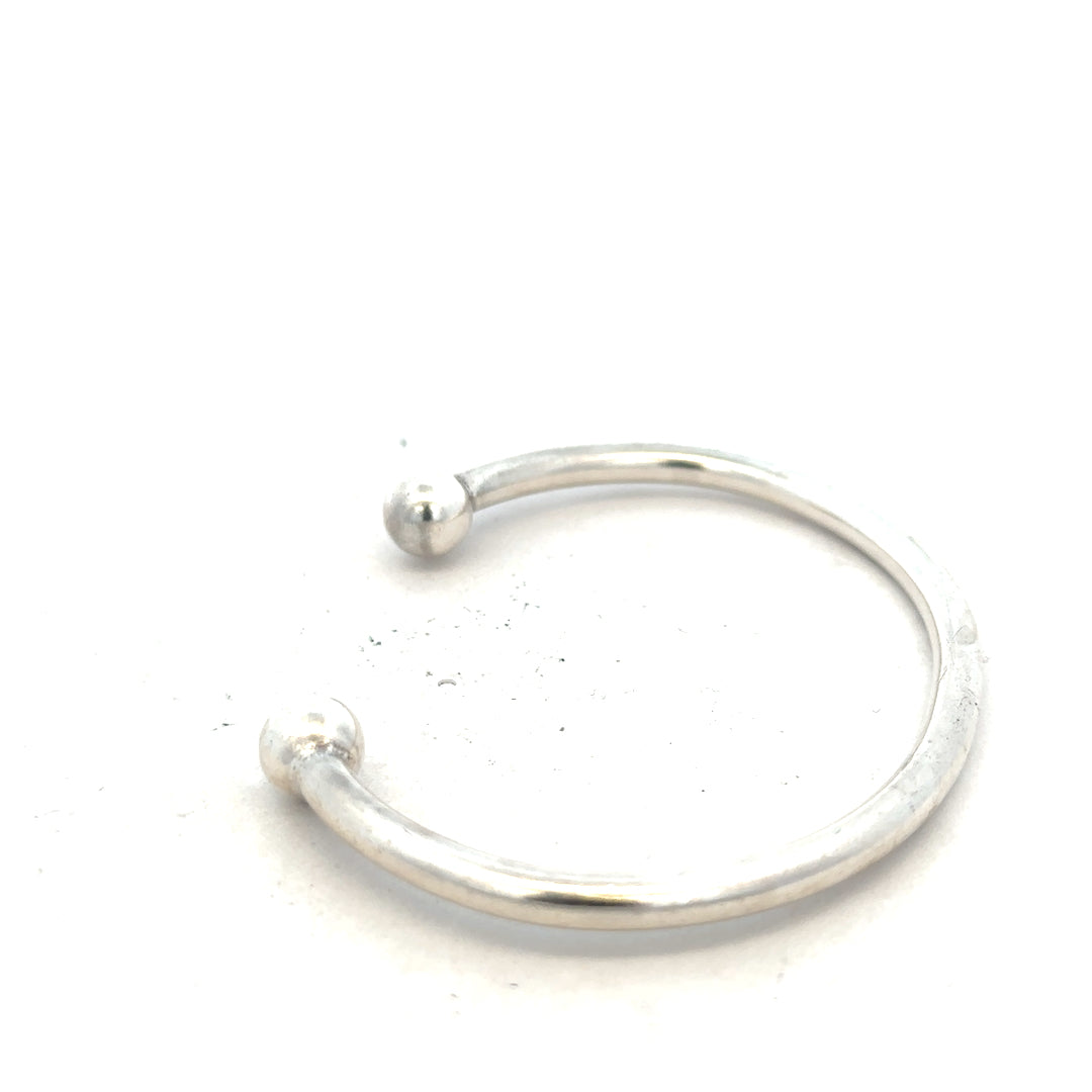 Silver torque bangle bracelet, unbranded 20g design with a sleek, polished finish on a plain background.